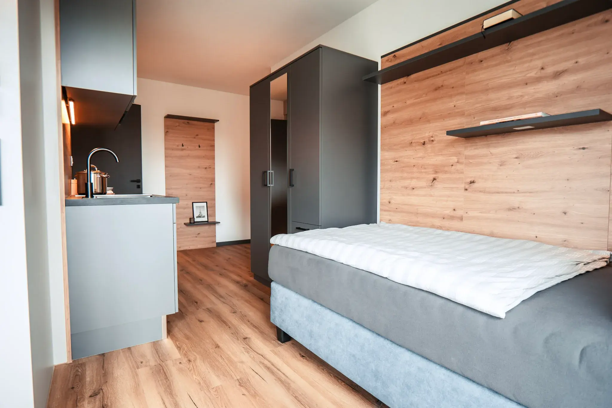 Bett und Kitchenette im Studio Apartment der Eighty-Eight Apartments Nürnberg